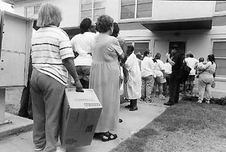 Residents wait in line at the weekly Capital Area Food Bank food drop.