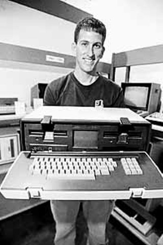 Alex Bilstein holding the first luggable computer, the 1981 Osborne 1